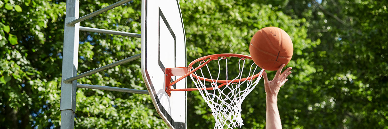 A boy is about to score a goal in basketball hoop.